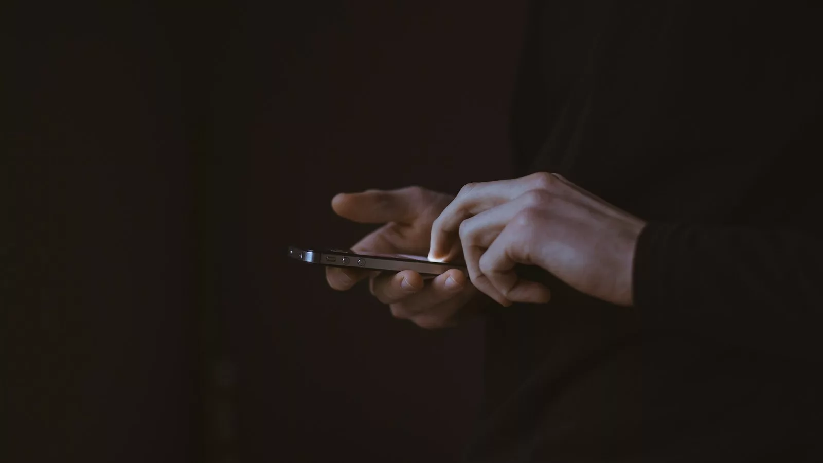 Silhouette photo of person holding smartphone