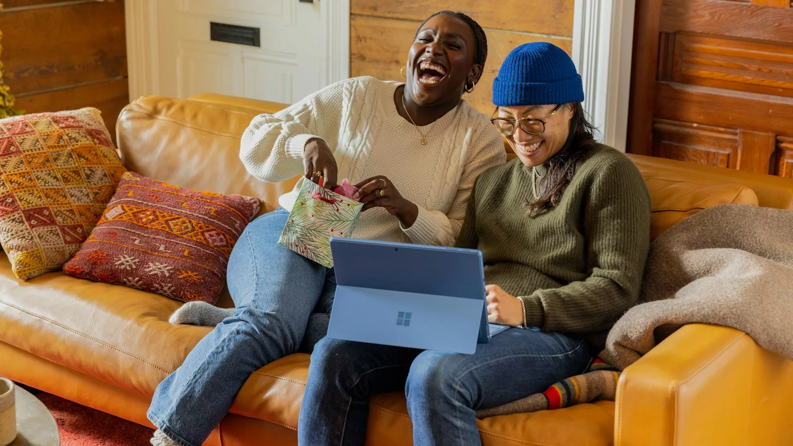 A person sitting on a couch with a laptop