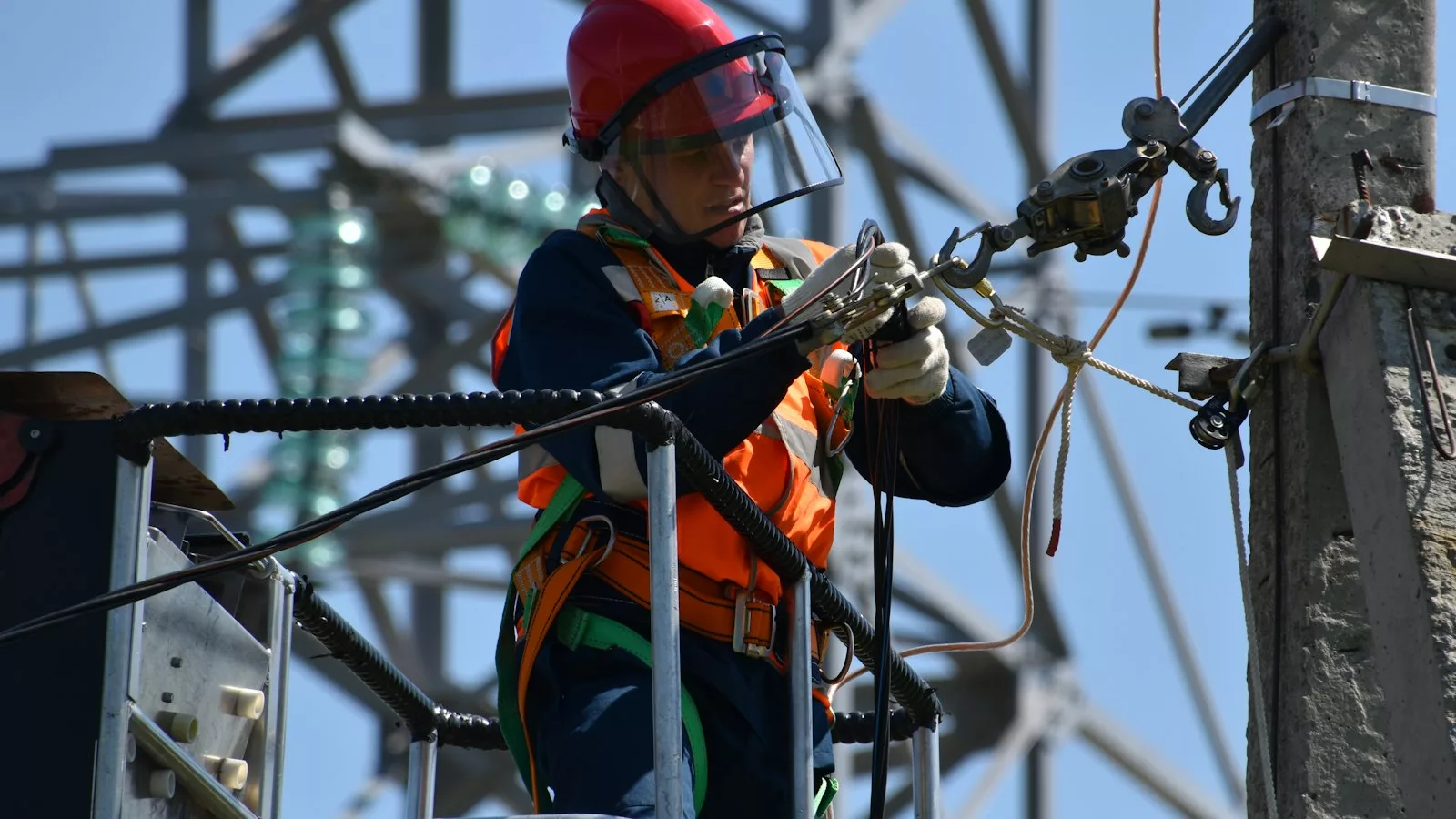 Shallow focus photo of man fixing steel cable