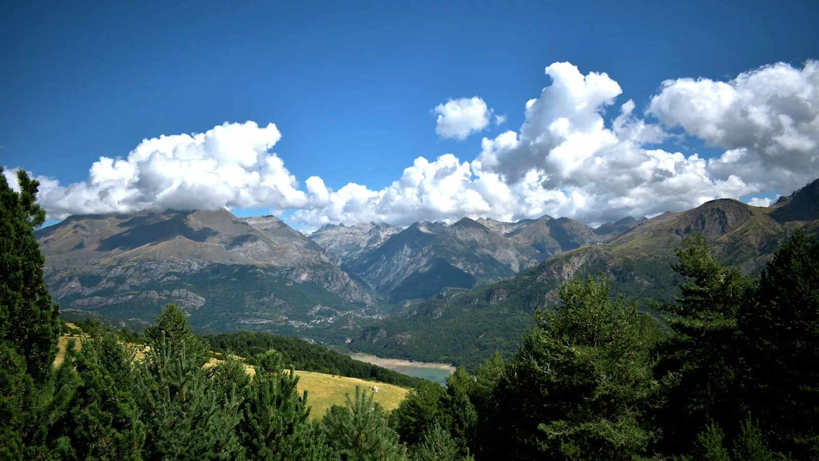 A scenic view of a mountain range with clouds in the sky