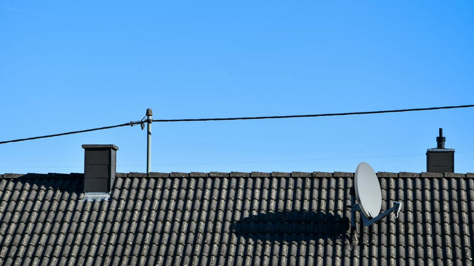Una antena parabòlica situada a la part superior d'una teulada