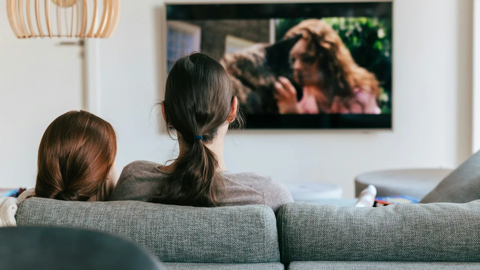A couple of women sitting on top of a couch